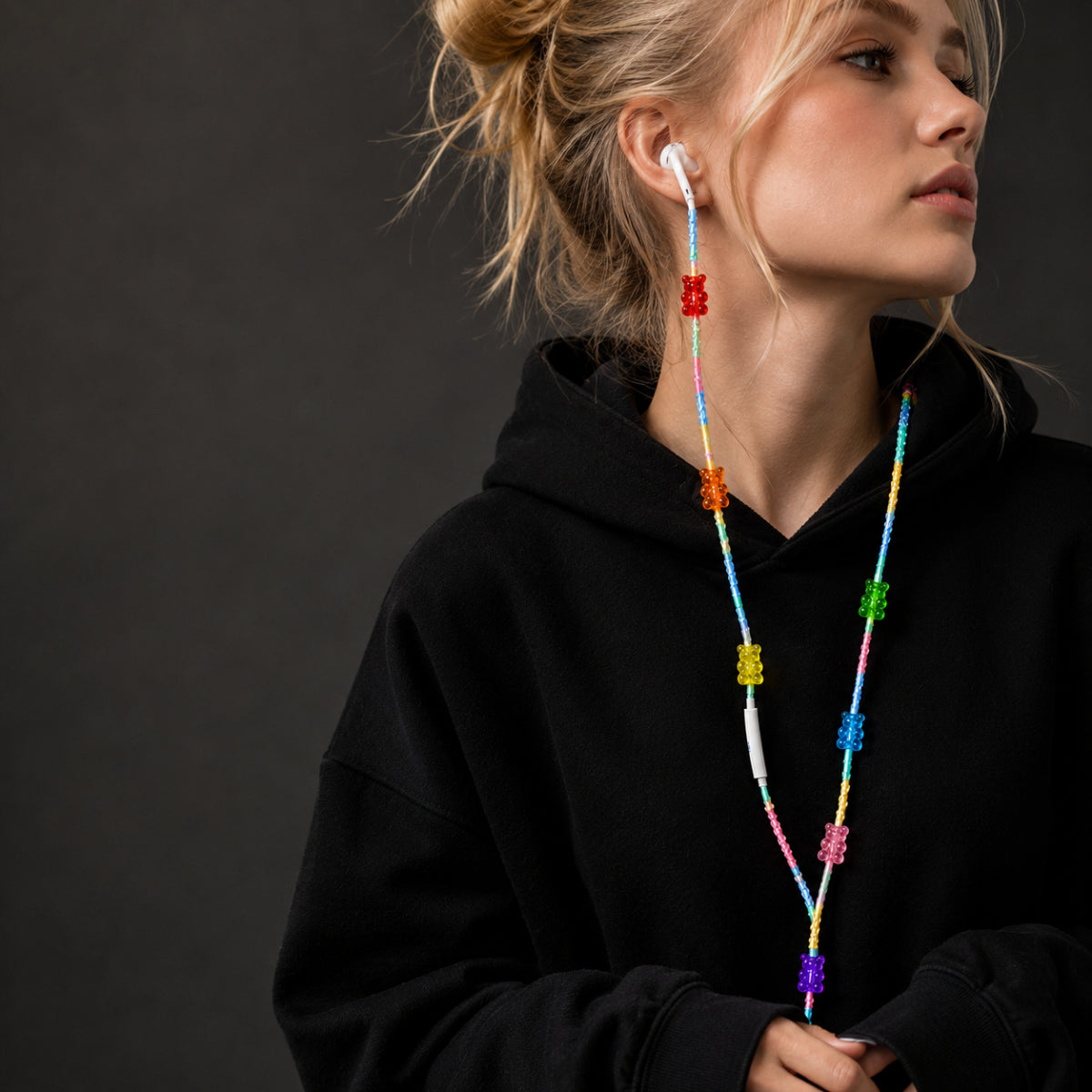 Model wearing Gummy Bear Earphone Wrap featuring rainbow braided cord and colorful candy bear charms.