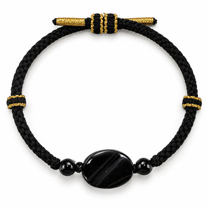 Black onyx bracelet for men with an oval striped onyx stone on black braided cord with gold-tone thread bands