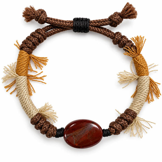 Red jasper bracelet with an oval brick-red stone on brown braided cord with mustard and cream wraps and fringe