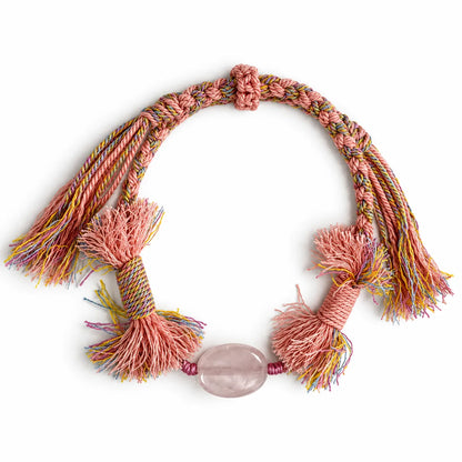 Rose quartz bracelet with an oval translucent pink stone on blush and pastel braided cord with full pink tassels