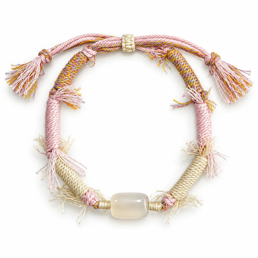 Crystals for love bracelet with a milky barrel-shaped quartz stone on pink and cream wrapped cord with fringe