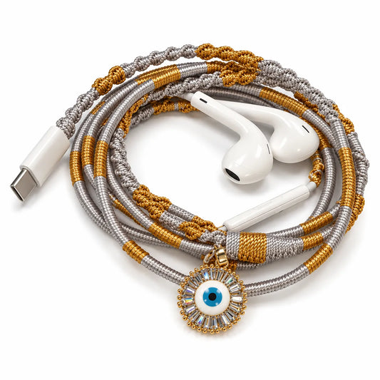 Sunburst evil eye charm with baguette stone halo on hand-wrapped gold and silver wired earphones