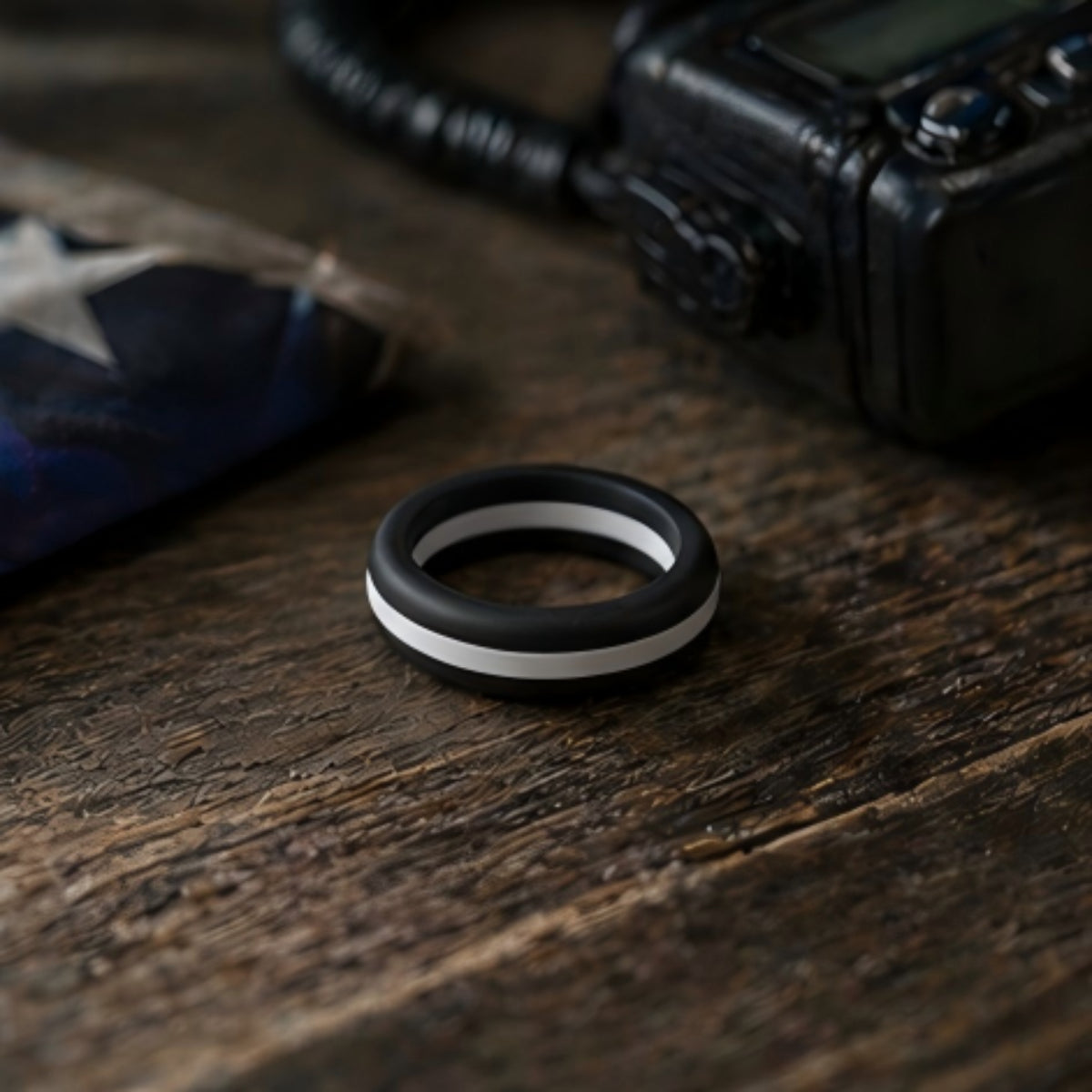 black and duty white EMS silicone ring beside radio and duty gear