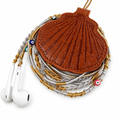 seashell wired earbuds case holding gold and silver braided earphones