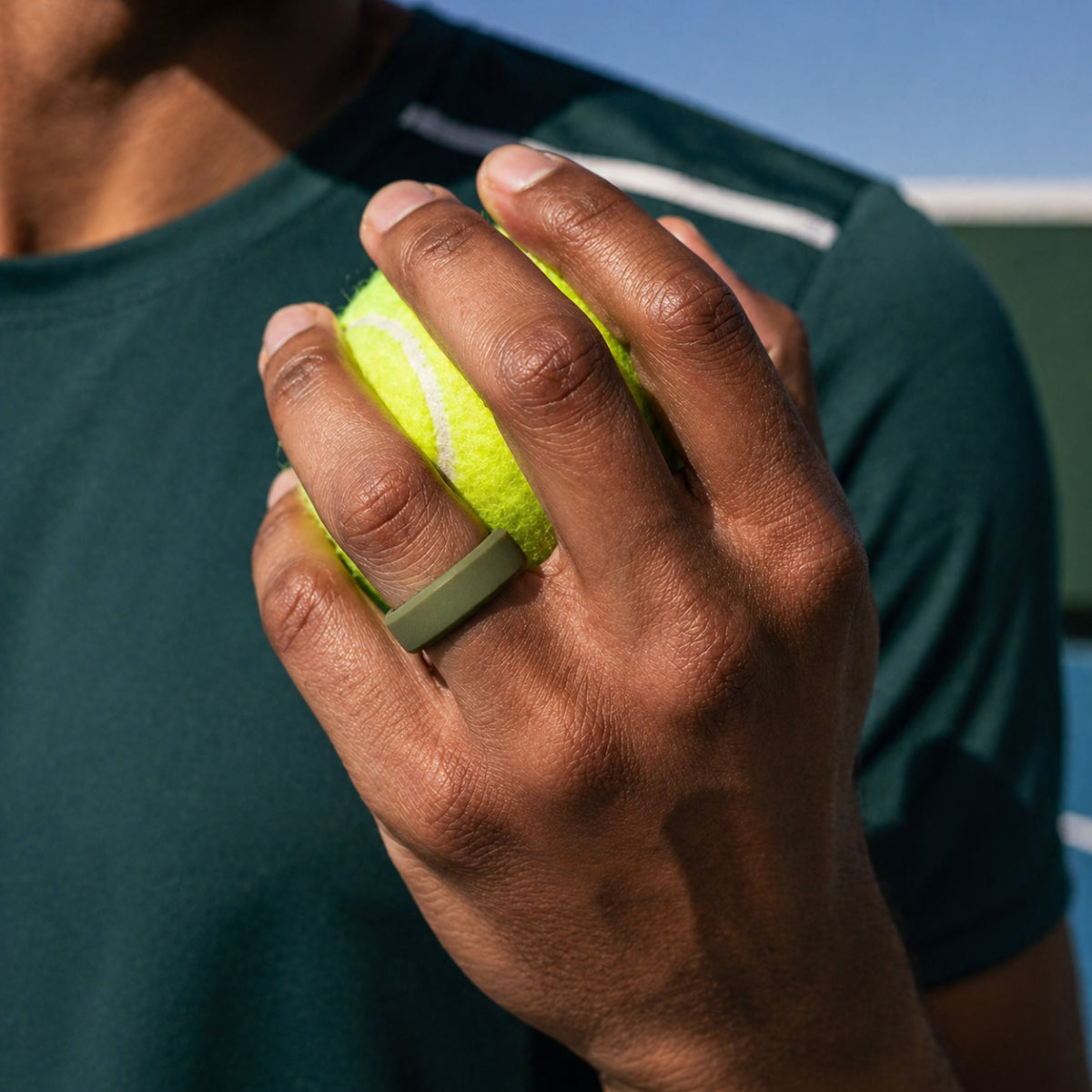 light grey domed silicone ring for men holding a tennis ball
