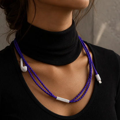  Deep violet earphone wrap worn draped down a woman's neck and collarbone against a black turtleneck, styled like a delicate necklace 